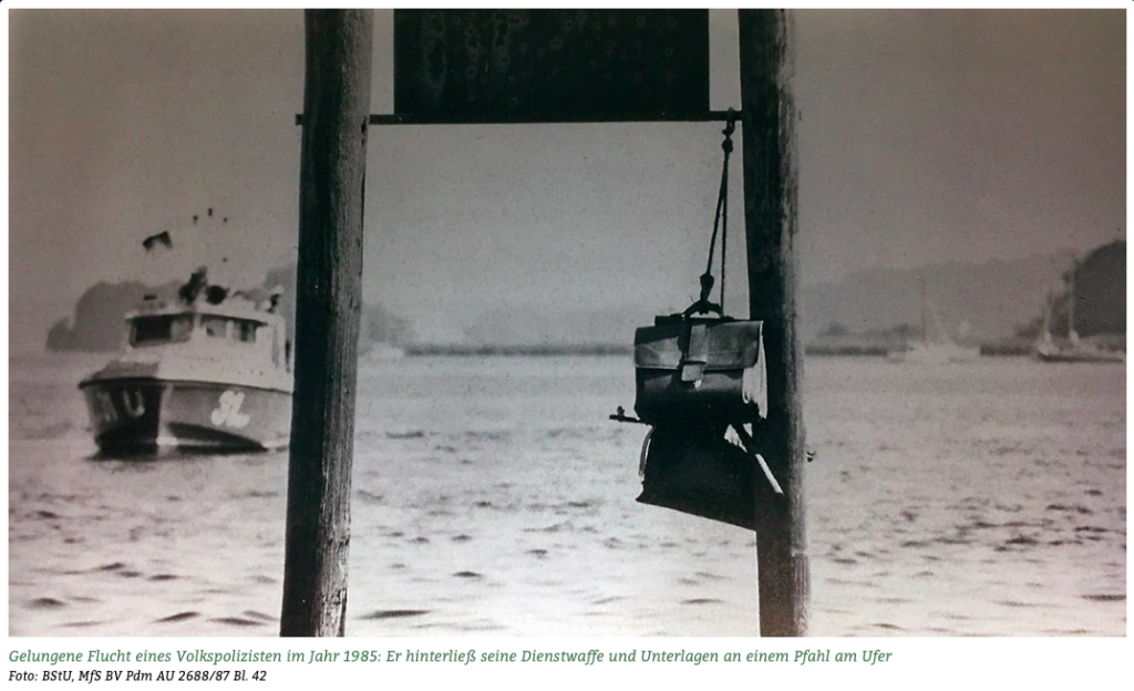 Kalaschnikow und Dokumente, im Hintergrund die Wasserschutzpolizei Westberlins (Foto: BStU, Leibniz-Zentrum für Zeithistorische Forschung Potsdam)